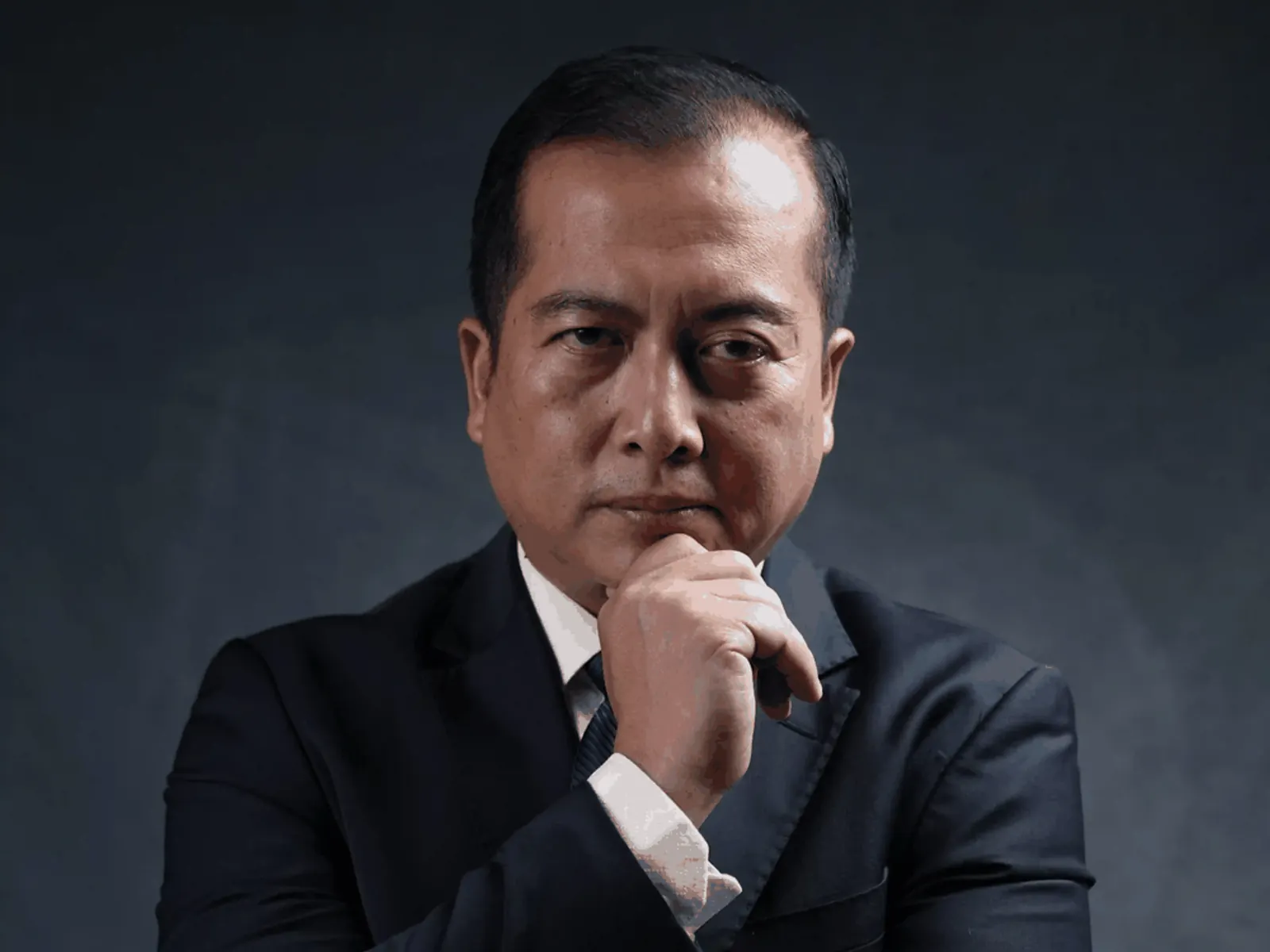 Professional portrait of a business executive in a suit with thoughtful expression